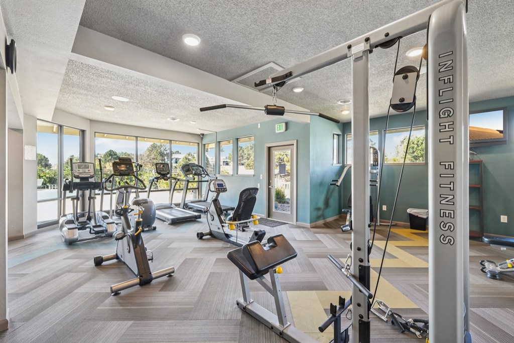 A gym with a variety of equipment including treadmills, exercise bikes, and weight machines.