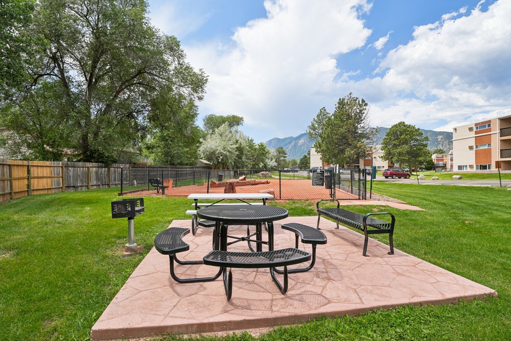 A picnic table and chairs are set up on a patio. at Broadmoor Springs, Colorado Springs