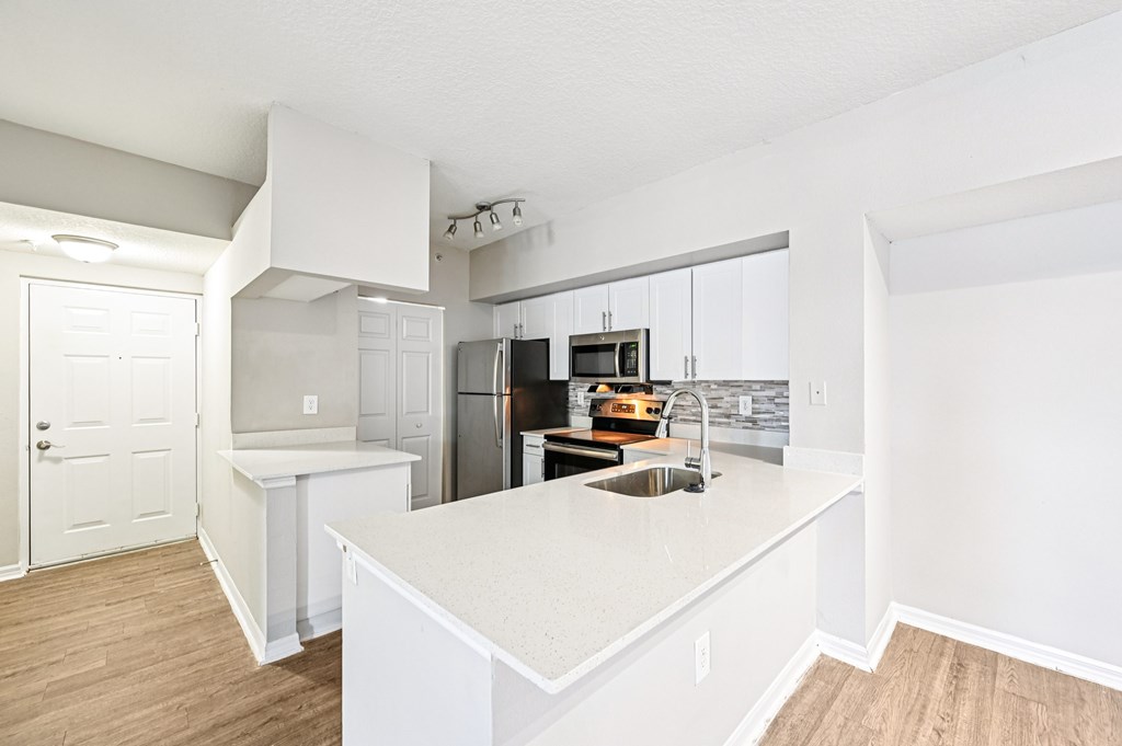 A kitchen with white cabinets and a white island. at Heritage Bay, Jensen Beach