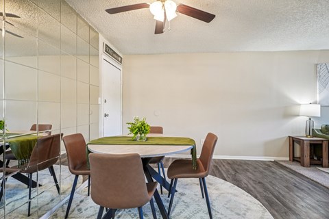 A dining room with a table and chairs.