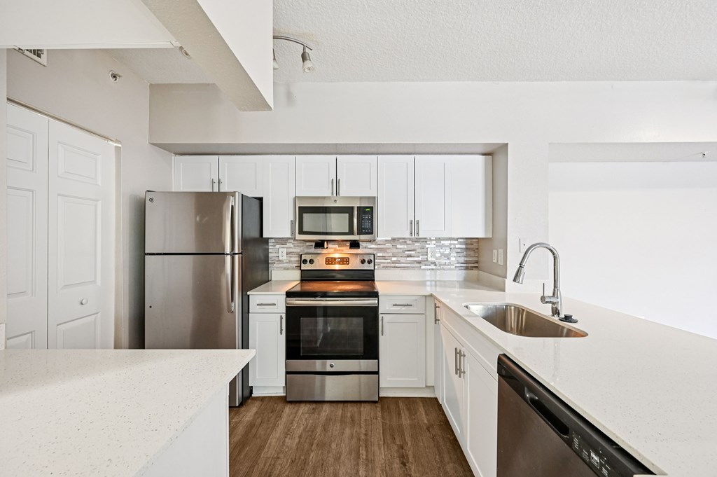 A modern kitchen with stainless steel appliances and white cabinetry. at Heritage Bay, Florida