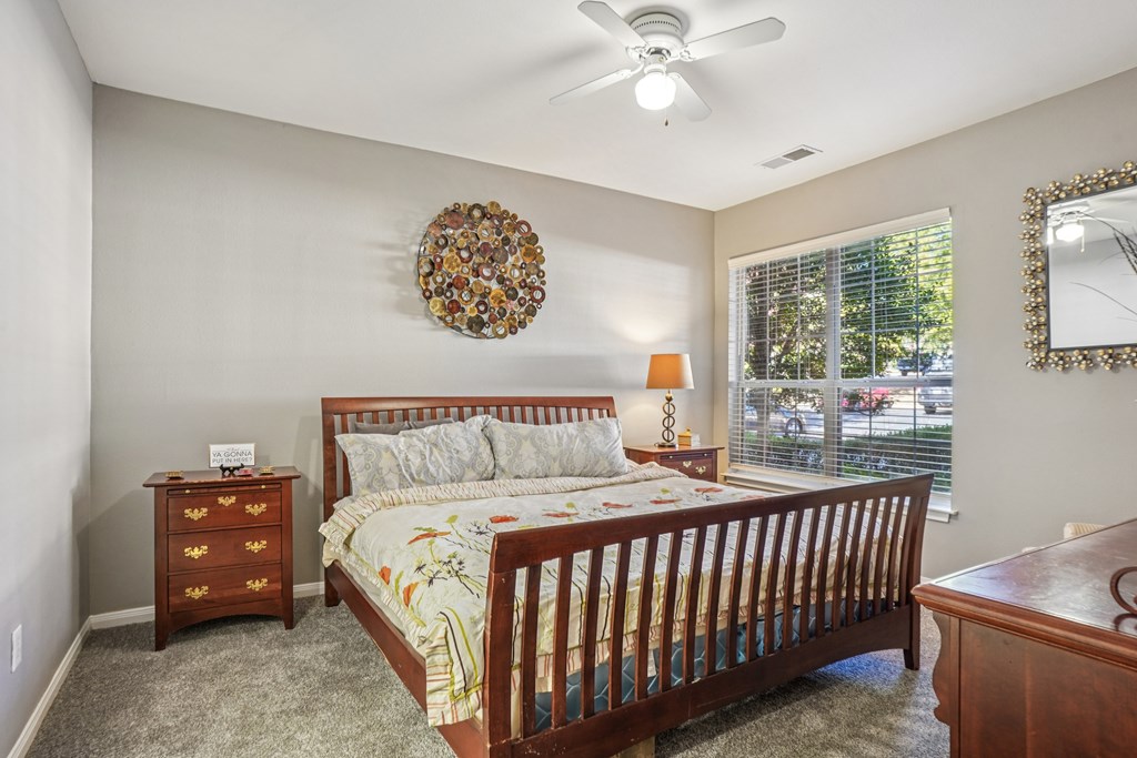 A bedroom with a bed, dresser, and mirror.