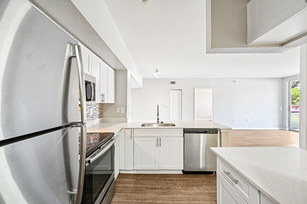 A modern kitchen with white cabinets and a large refrigerator. at Heritage Bay, Florida, 34957