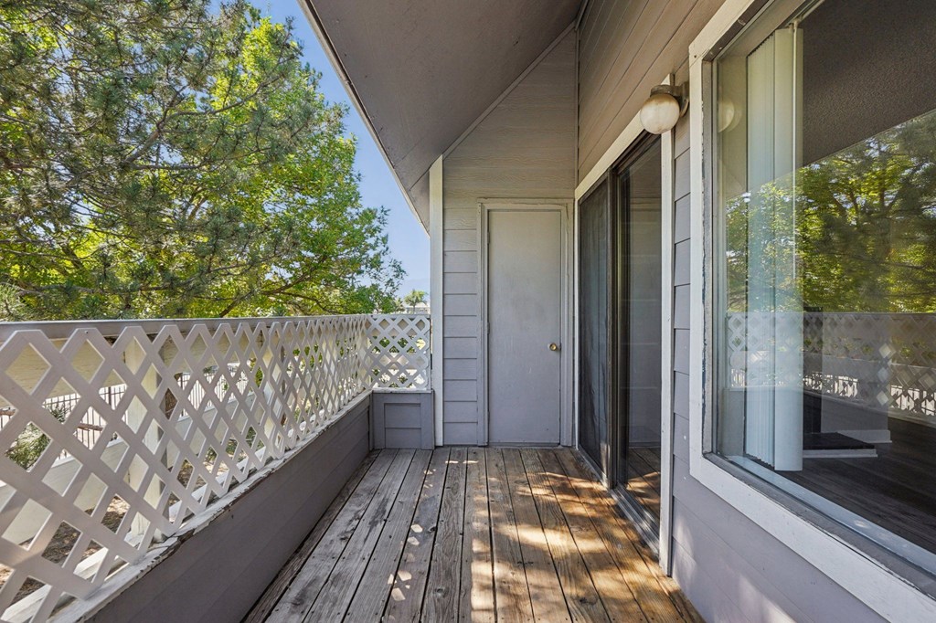 A balcony with a white railing and a door.
