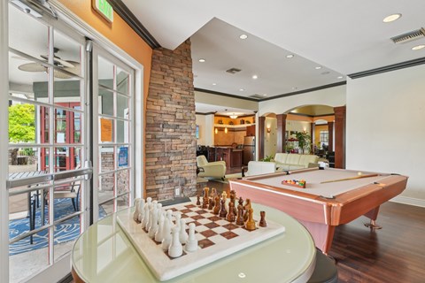 A pool table with a chess board on top of it.