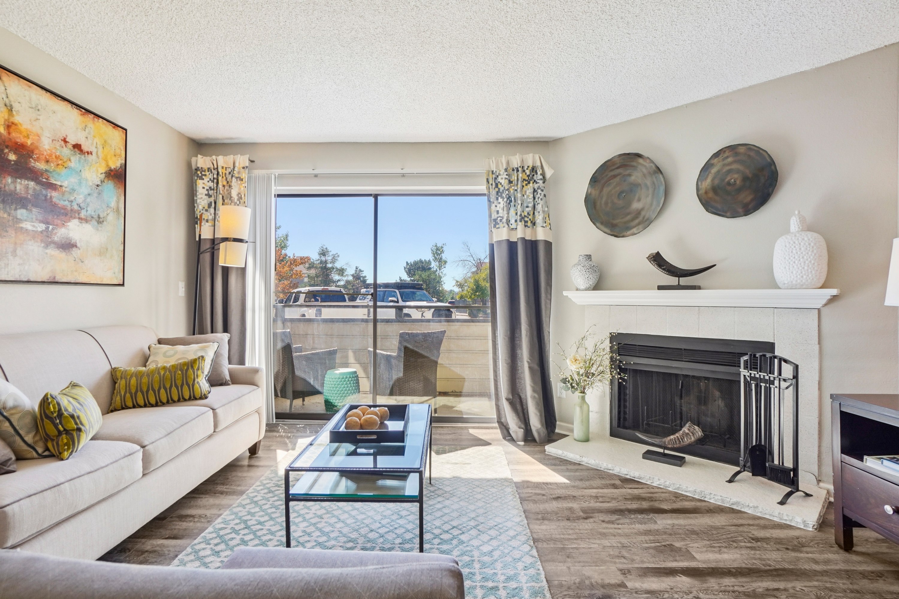 A living room with a fireplace and a painting on the wall.