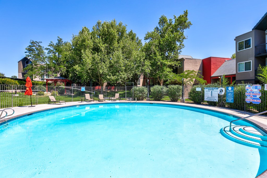 A swimming pool surrounded by trees and chairs. at Glen at Hidden Valley, Reno, NV