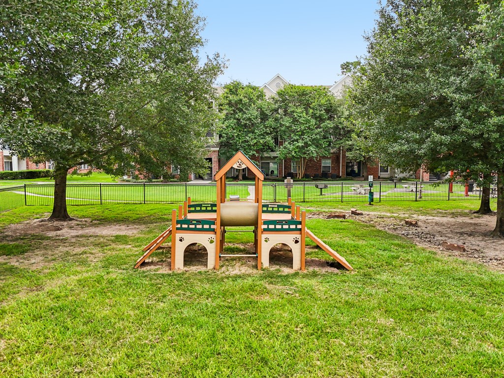 A playground with a slide and a sandbox in the foreground.at Kingwood Glen, Kingwood