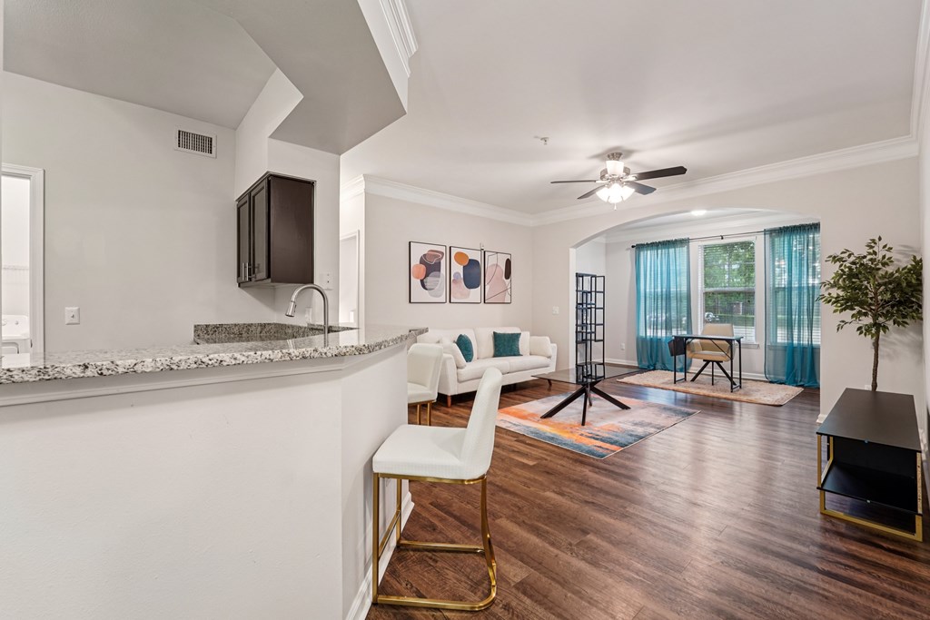 A modern kitchen with a bar stool and a counter.at Kingwood Glen, Kingwood