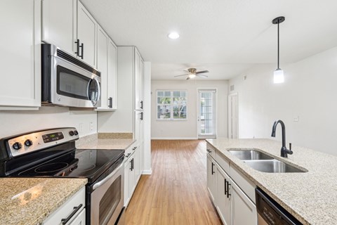 A kitchen with white cabinets and a granite countertop.