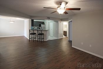 Empty living room with a kitchen in the background and ceiling fan at Pembroke Pines Landings, Florida, 33025