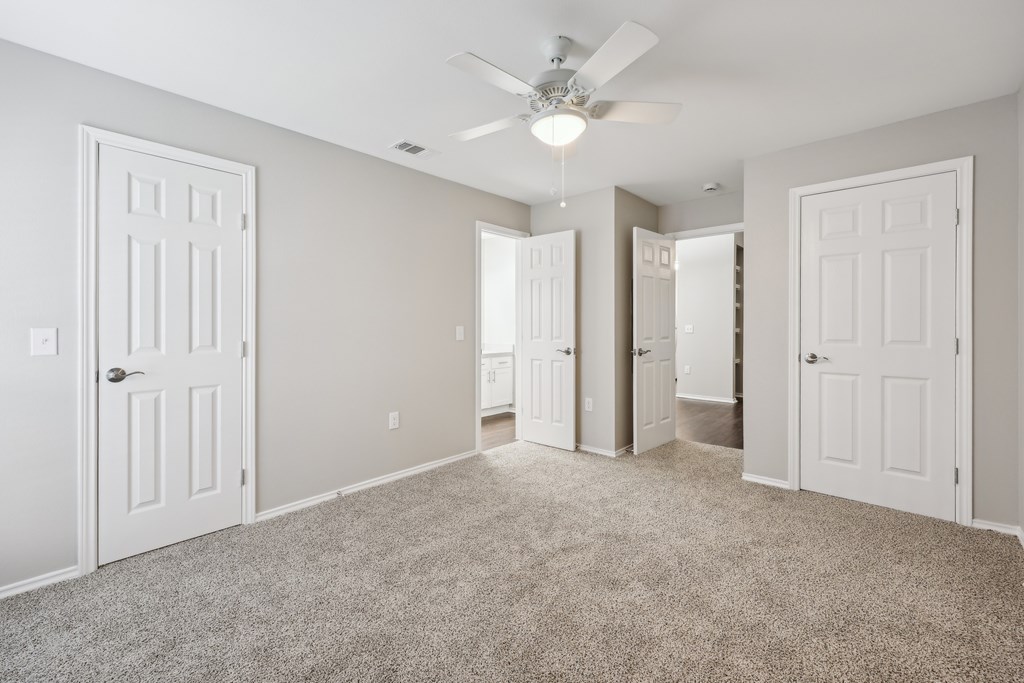 A spacious room with a carpeted floor and a ceiling fan at The Willows on Rosemeade, Dallas, TX 75287