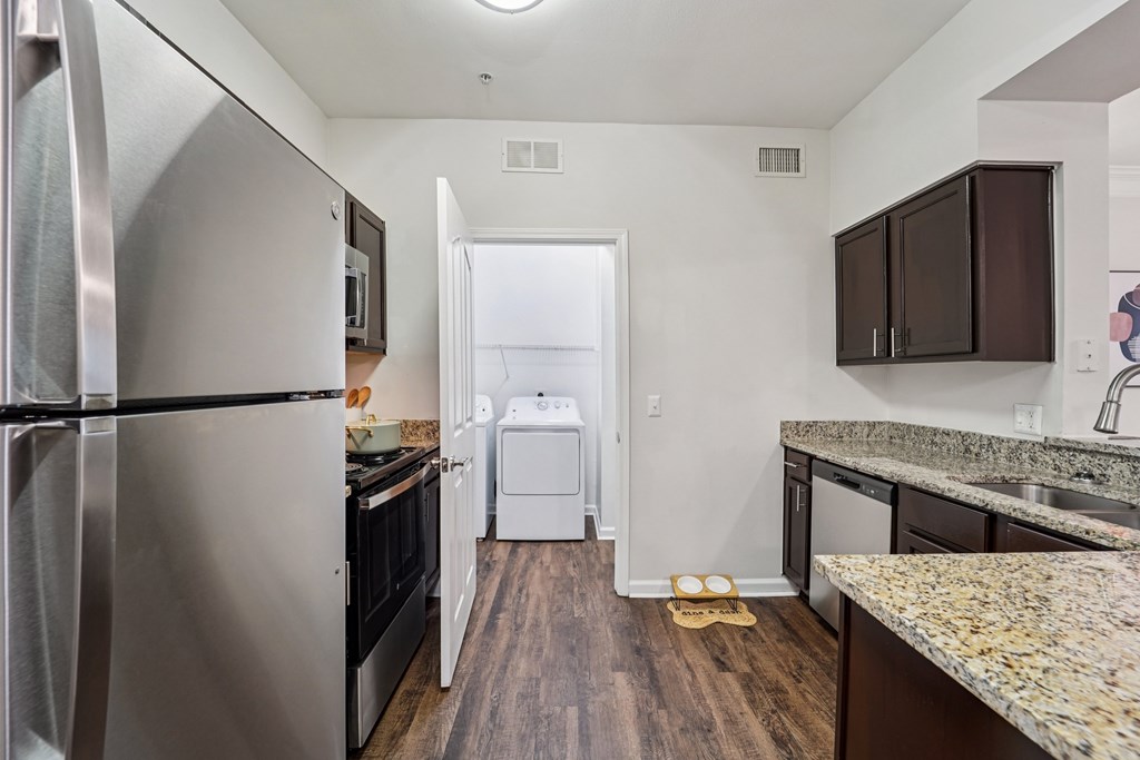 A kitchen with a refrigerator, oven, and dishwasher.at Kingwood Glen, Texas, 77339