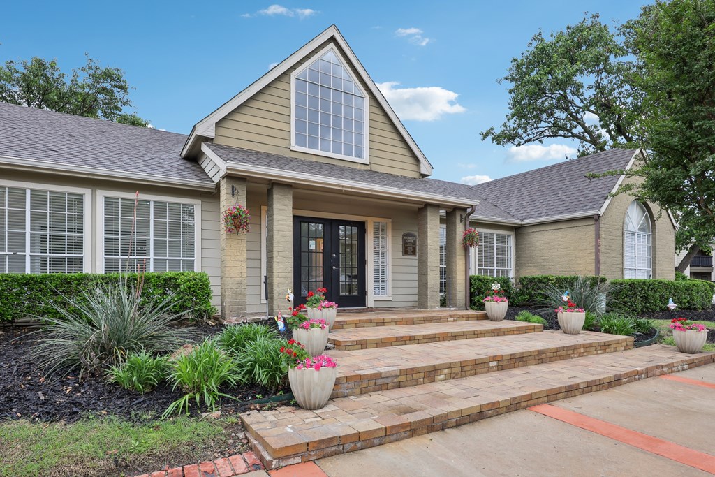 A house with a front yard and steps leading to the front door at The Willows on Rosemeade, Dallas, TX 75287