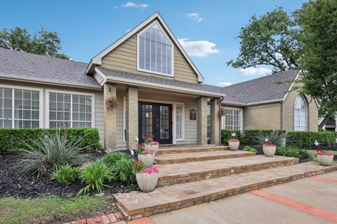 A house with a front yard and steps leading to the front door.