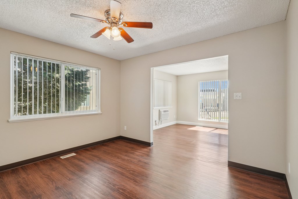 A room with a ceiling fan and wooden flooring.at Aspen Townhomes, Colorado Springs, Colorado
