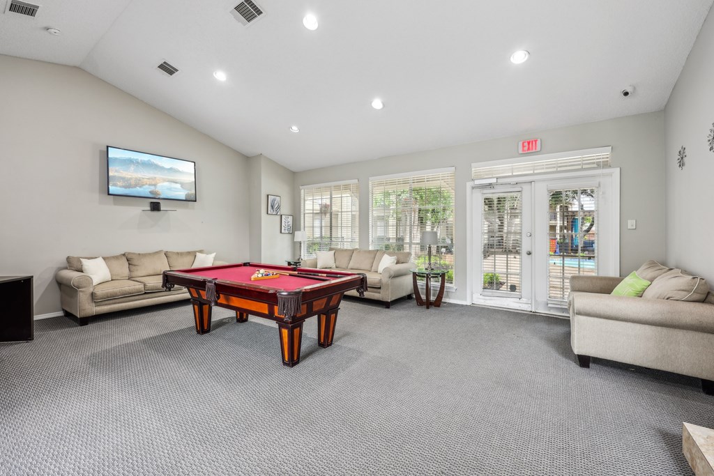 A room with a pool table and a television at The Willows on Rosemeade, Dallas, TX 75287