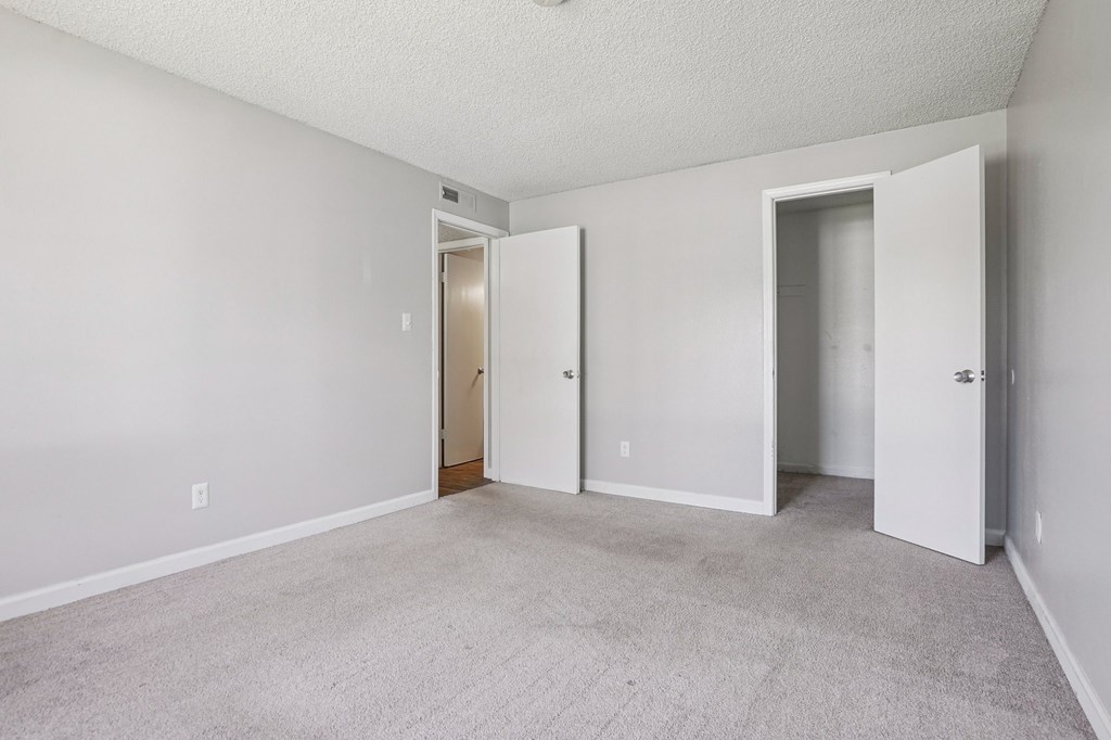 A room with two doors and a carpeted floor.