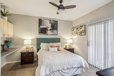 A bedroom with a large bed and a ceiling fan at Sweetwater At Metro North Apartments, Phoenix, AZ
