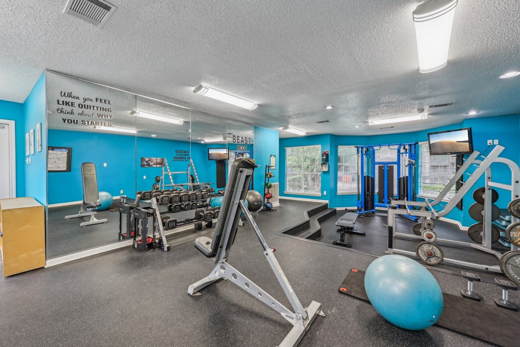A gym with a blue wall and a variety of equipment.