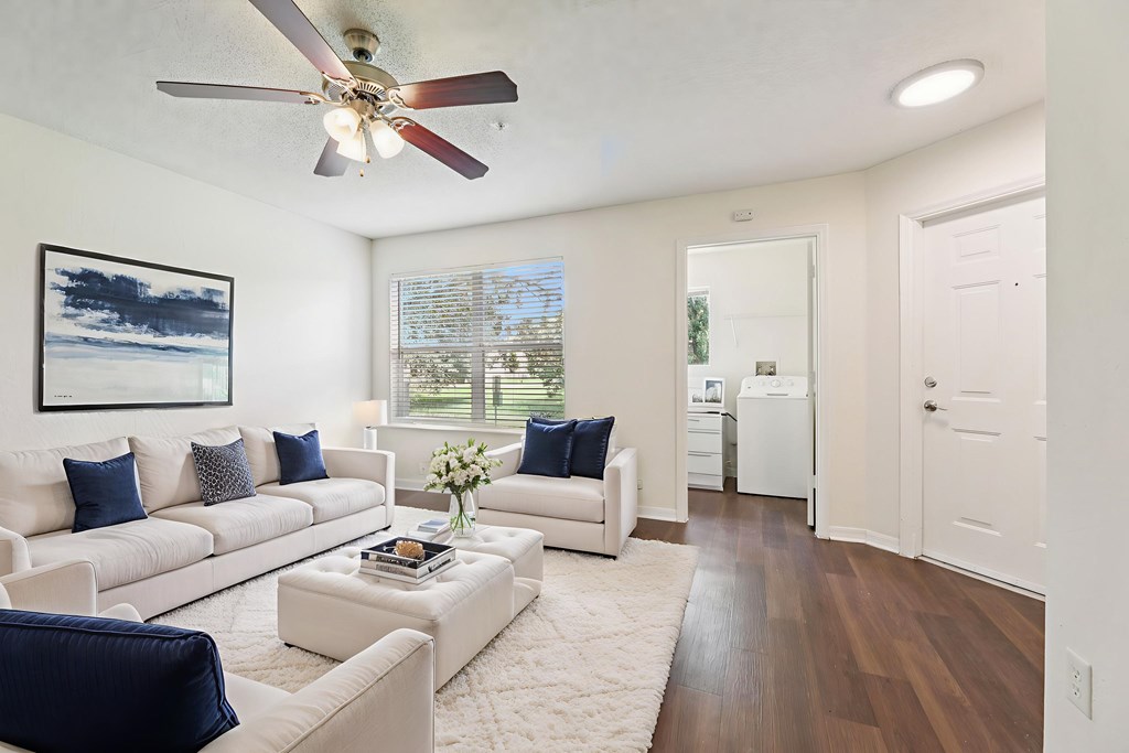 A living room with a white couch and a ceiling fan. at University Park Apartments, Florida, 32817