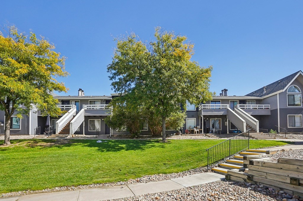 A row of houses with a green lawn in front.