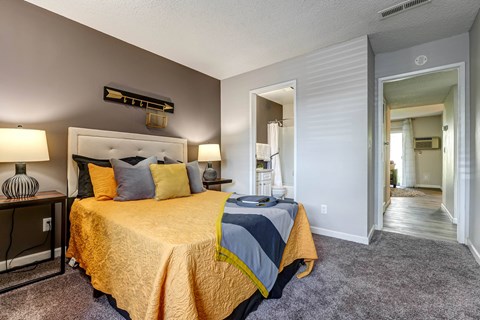 Bedroom with a bed and a door to a bathroom  at Union Heights Apartments, Colorado Springs, CO