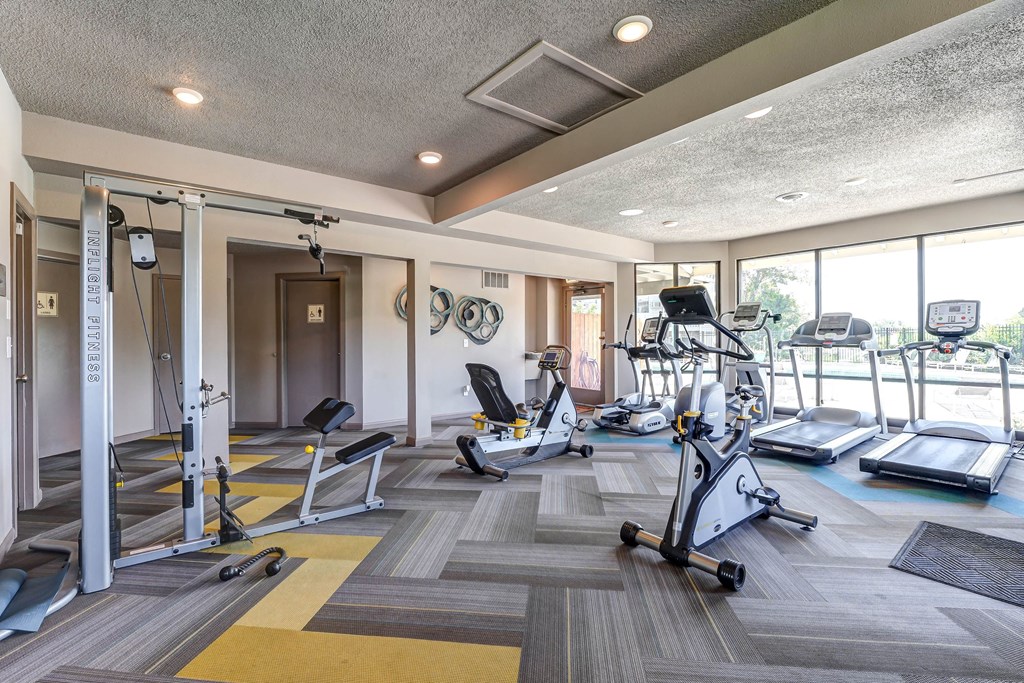 Gym with weights and cardio machines and windows  at Union Heights Apartments, Colorado Springs, CO