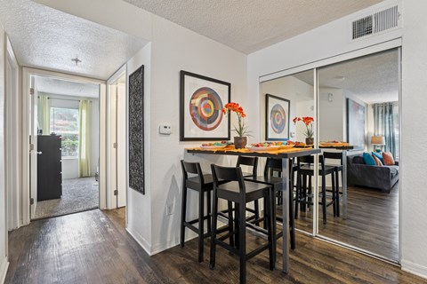 A dining room with a wooden table and chairs.