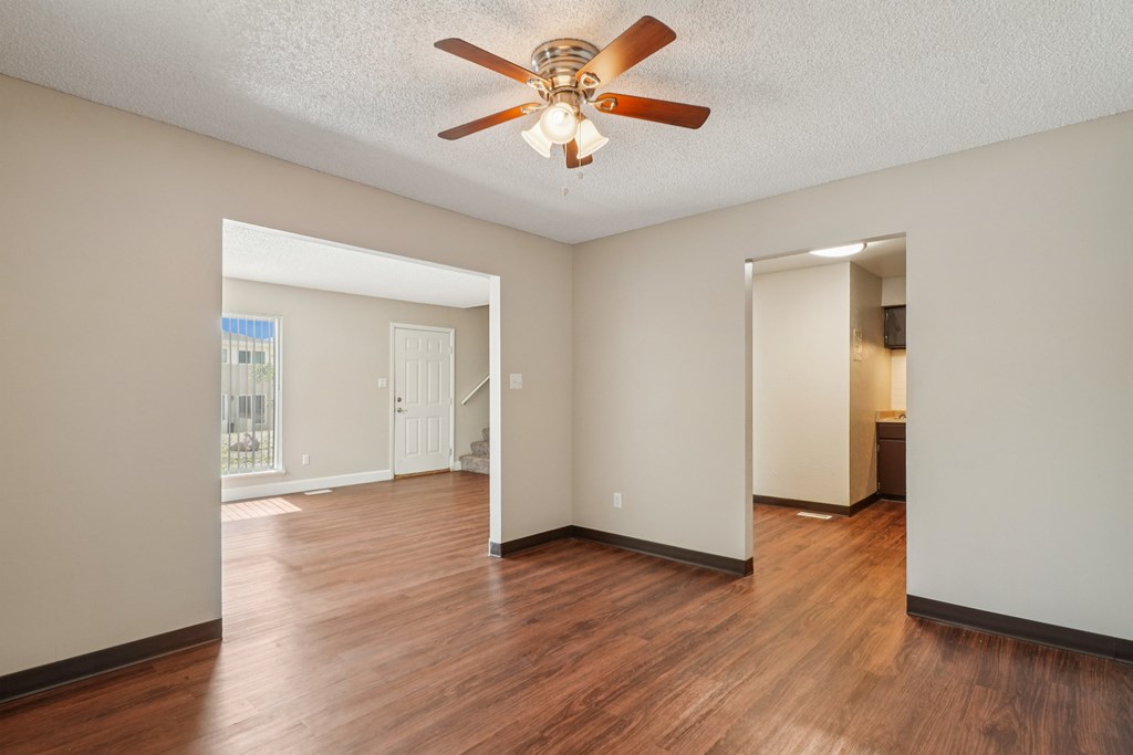 A room with a ceiling fan and wooden floors.at Aspen Townhomes, Colorado Springs, CO