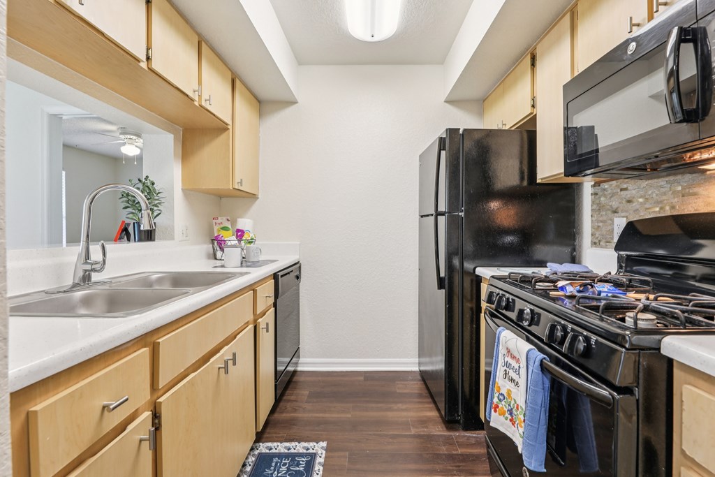 A kitchen with a black refrigerator and stove. at University Park Apartments, Orlando, FL
