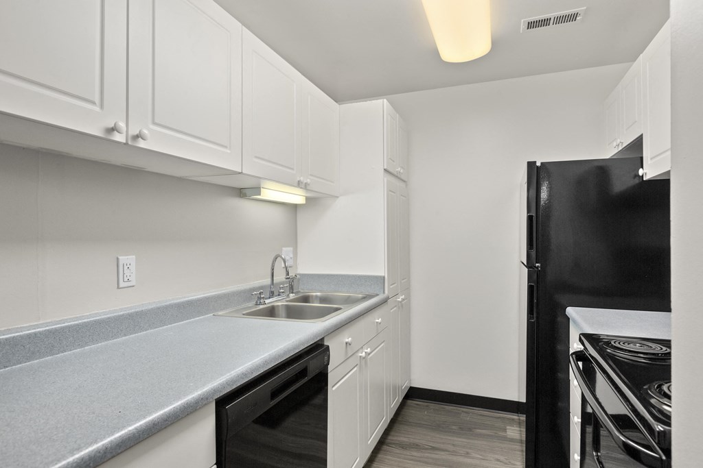Kitchen with white cabinets and black appliances at Creve Coeur, Creve Coeur, MO