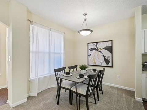 A dining room with a table set for four.
