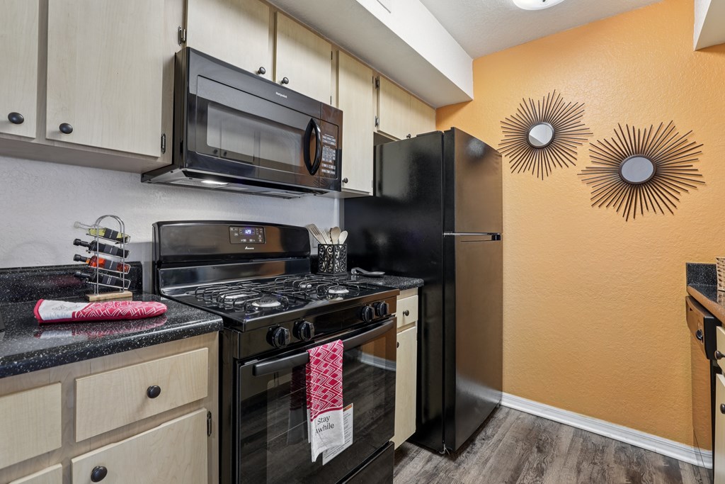 A kitchen with black appliances and wooden cabinets. at University Park Apartments, Orlando, FL, 32817