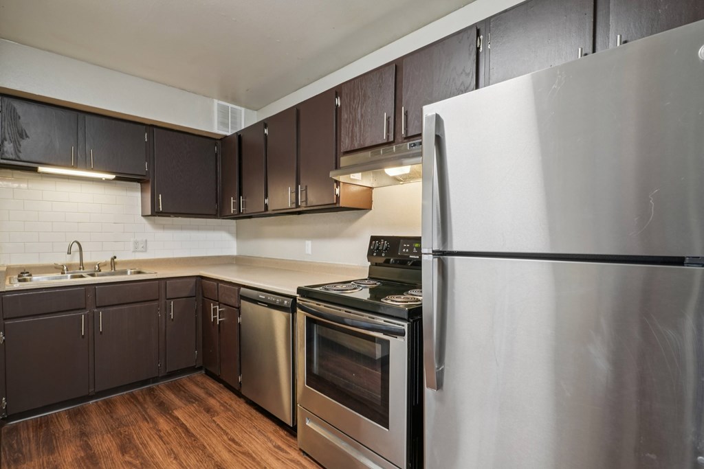 A kitchen with a stainless steel refrigerator, oven, and sink. at Aspen Townhomes, Colorado Springs, 80909