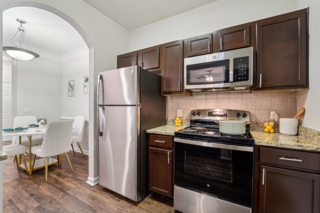 A kitchen with brown cabinets and a stainless steel refrigerator. Kingwood Glen, Kingwood, TX