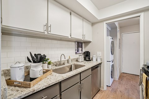 A kitchen with a white fridge and a marble counter top.