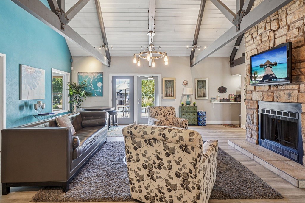 A living room with a stone fireplace and a large leopard print chair.