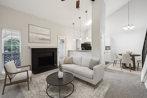 A living room with a fireplace, a couch, a chair, and a coffee table.