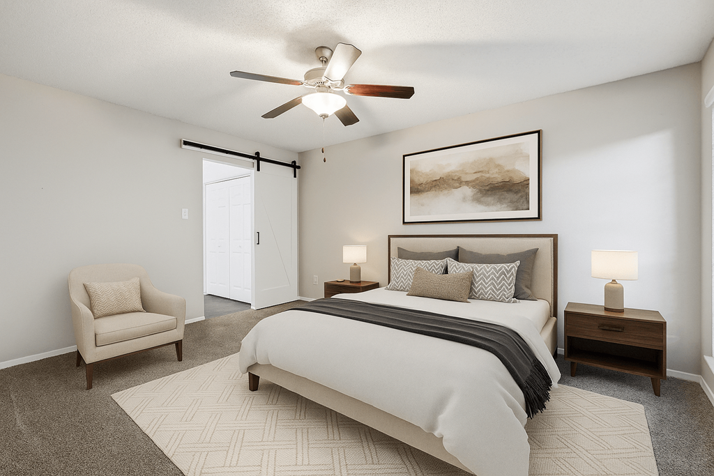 A bedroom with a large bed, a chair, and a ceiling fan at The Willows on Rosemeade, Dallas, TX 75287