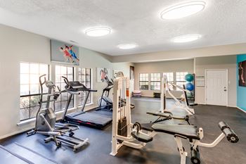 A gym with a variety of exercise equipment including treadmills, stationary bikes, and weight machines. at The Glen, Lewisville, TX