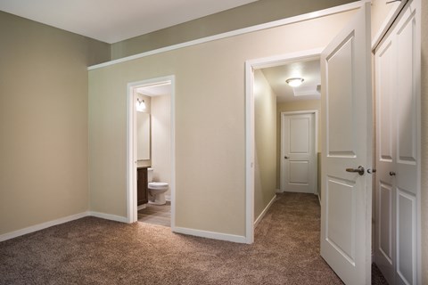 A bedroom with two doors and a bathroom in the background at Arcadia Townhomes, Federal Way, WA