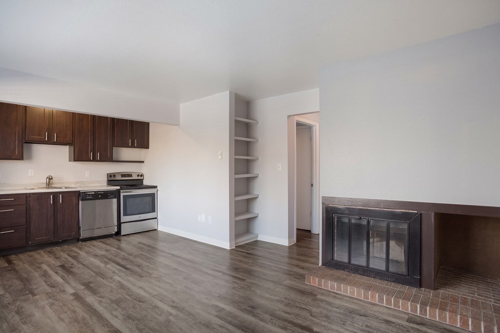 Empty living room with a fireplace and a kitchen   at Governor's Park, Fort Collins, 80525