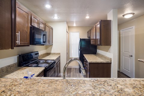 A kitchen with granite style countertops and black appliances at Arcadia Townhomes, Federal Way, WA