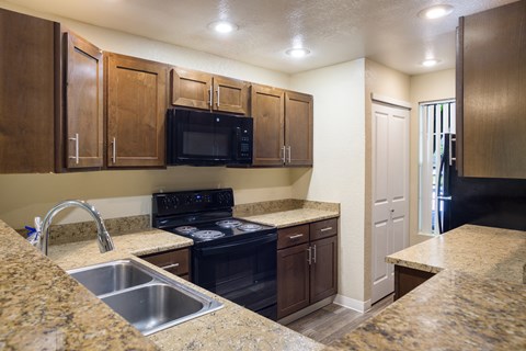 A kitchen with wooden cabinets and granite style countertops at Arcadia Townhomes, Federal Way, WA
