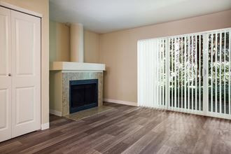 A living room with a fireplace and a large window at Arcadia Townhomes, Federal Way, WA