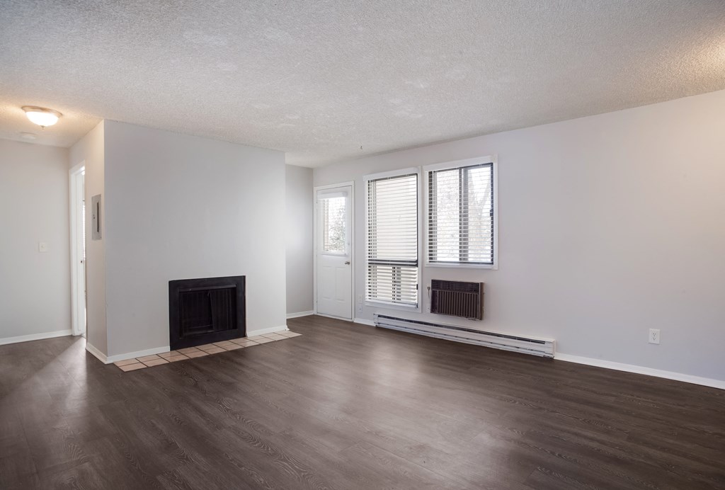Empty living room with a fireplace and wooden floors  at Governor's Park, Fort Collins, 80525