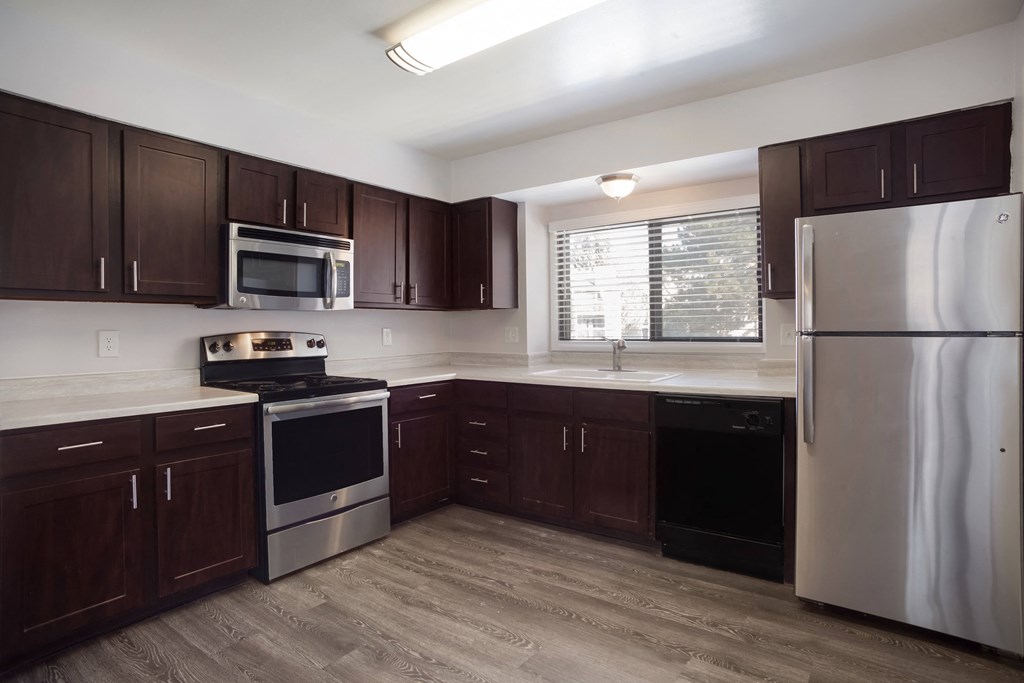 Kitchen with dark wood cabinets and stainless steel appliances  at Governor's Park, Fort Collins, 80525