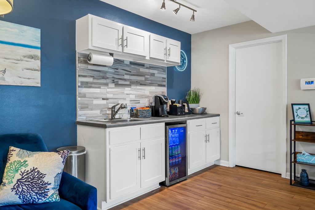 Clubhouse kitchen with white cabinets and a blue wall at Lofts of Wilmington, Wilmington, NC