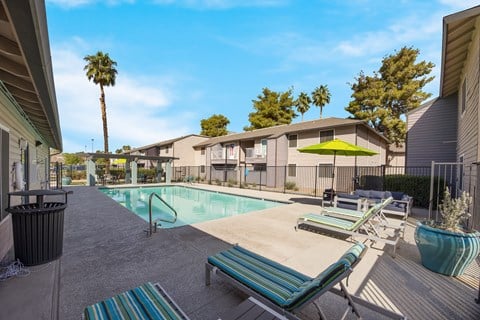 Swimming pool with lounge chairs and umbrellas at 2900 Lux Apartment Homes, Nevada